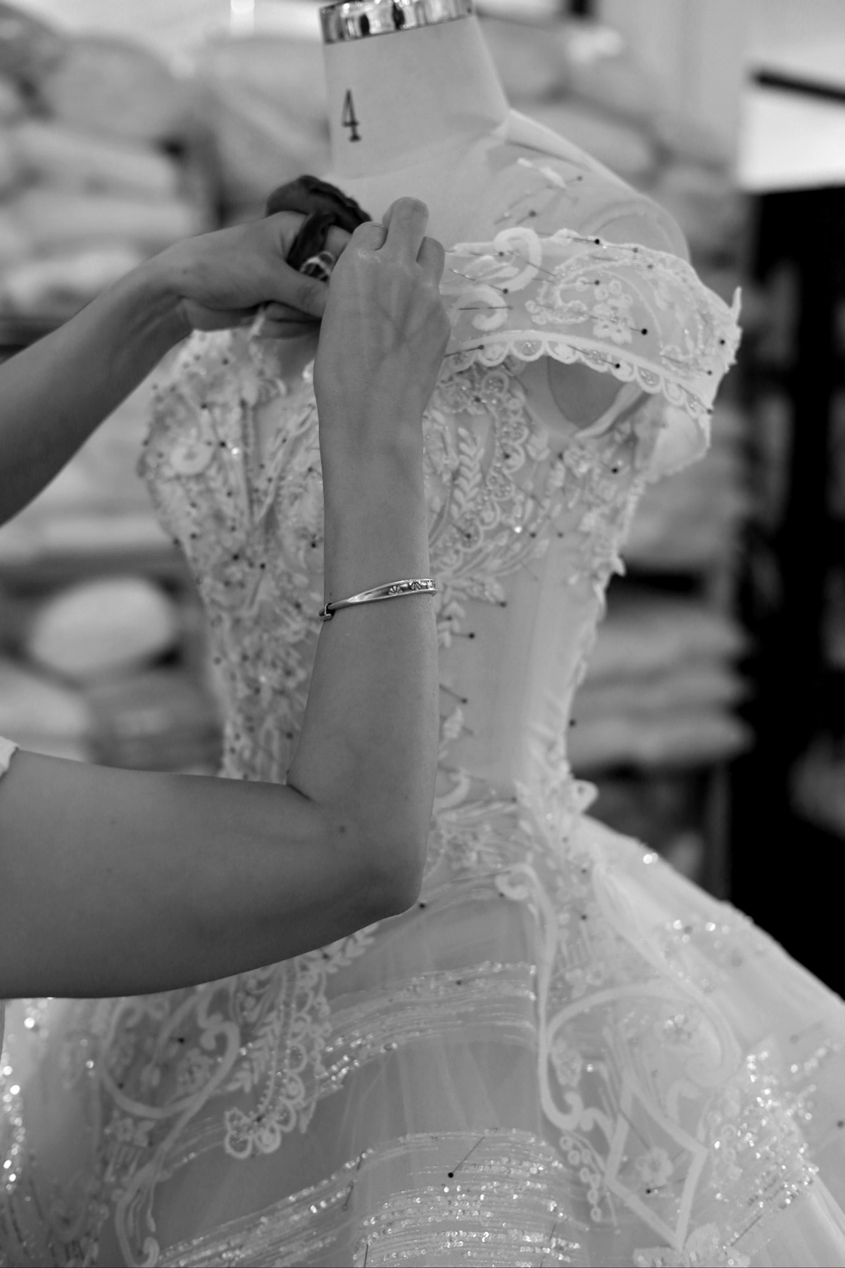 Lace appliqué positioned by hand on a dress form