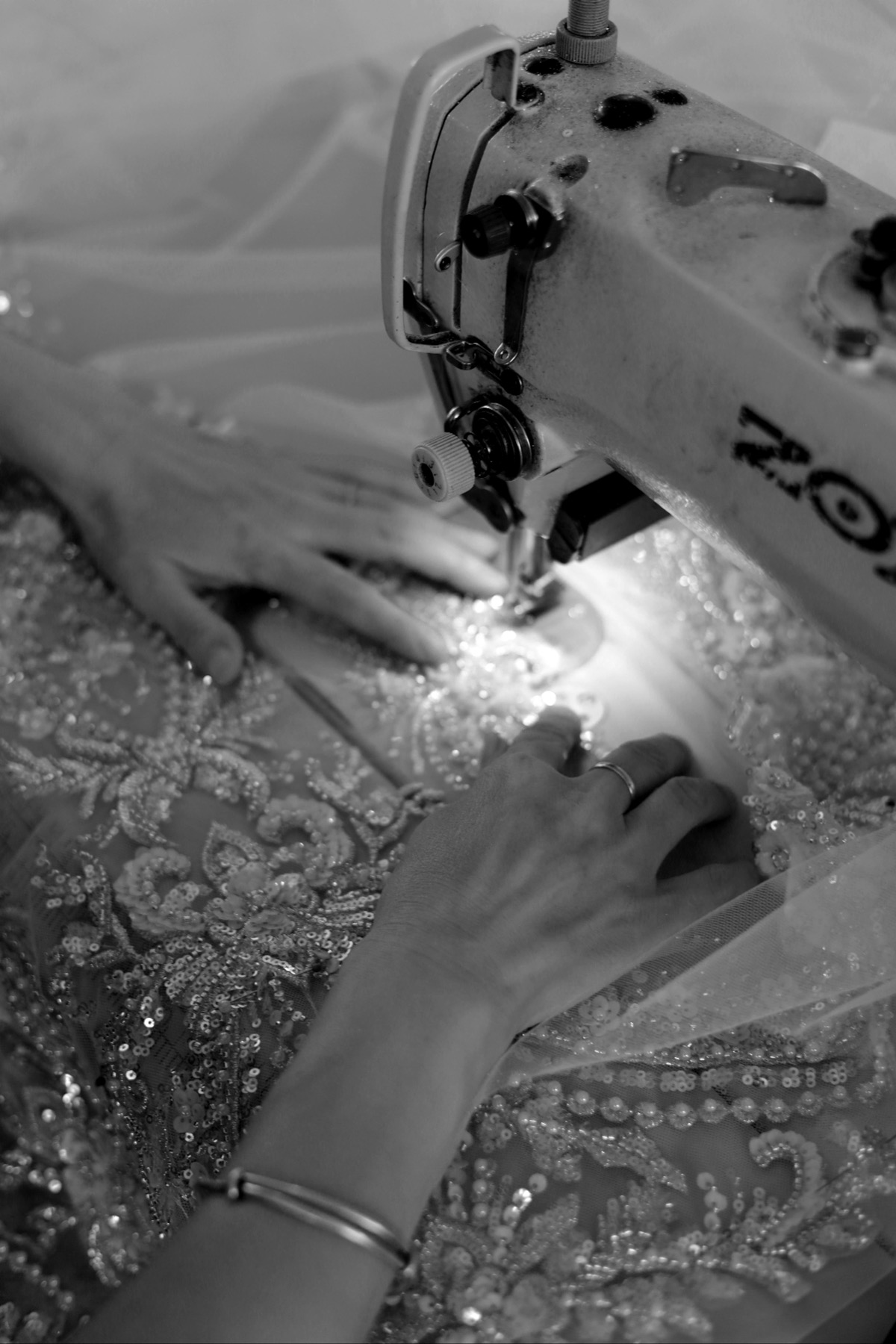 Embroidered bridal fabric being stitched at a sewing machine